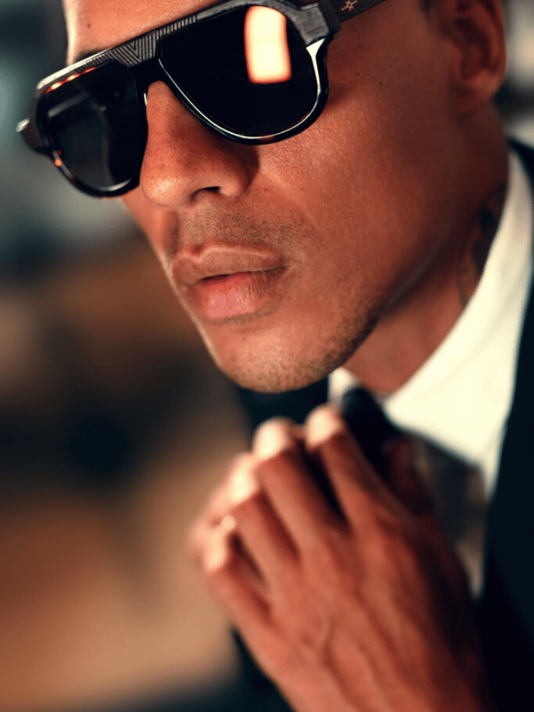 A man in a suit and tie is wearing sunglasses