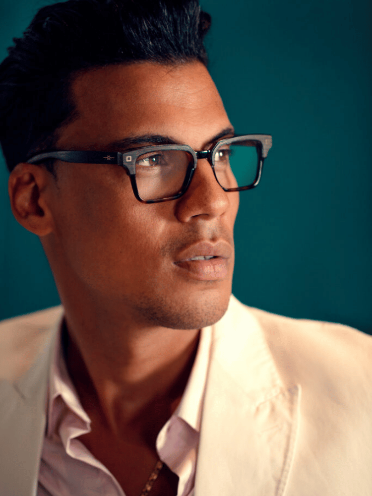 A close up of a man wearing glasses and a white jacket