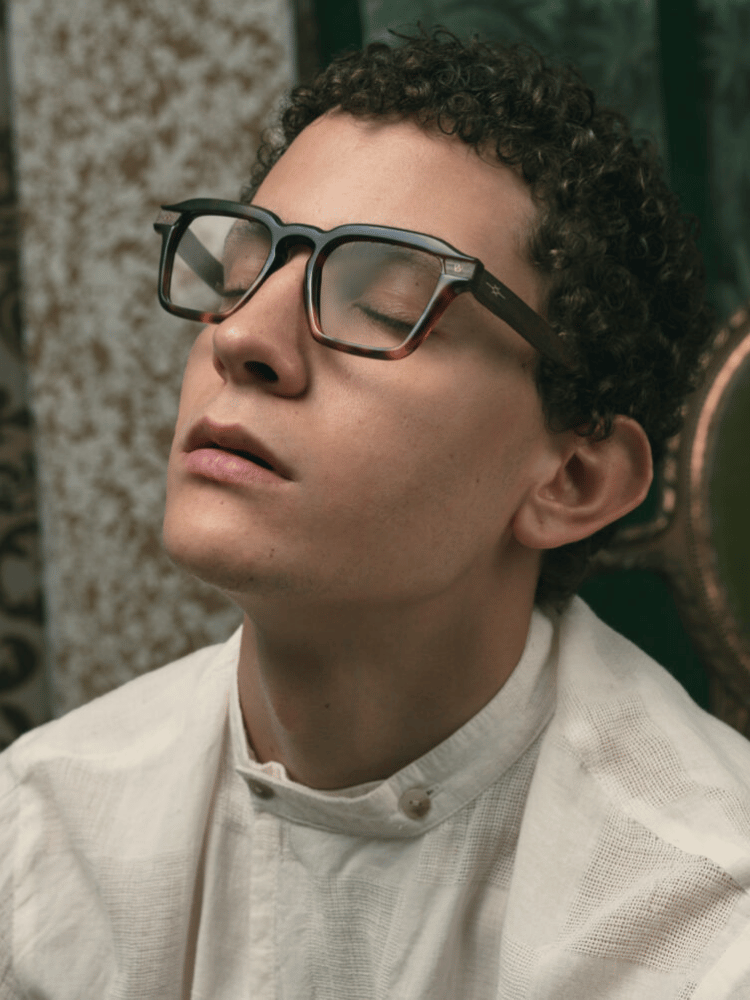 A close up of a man wearing glasses and a white shirt.