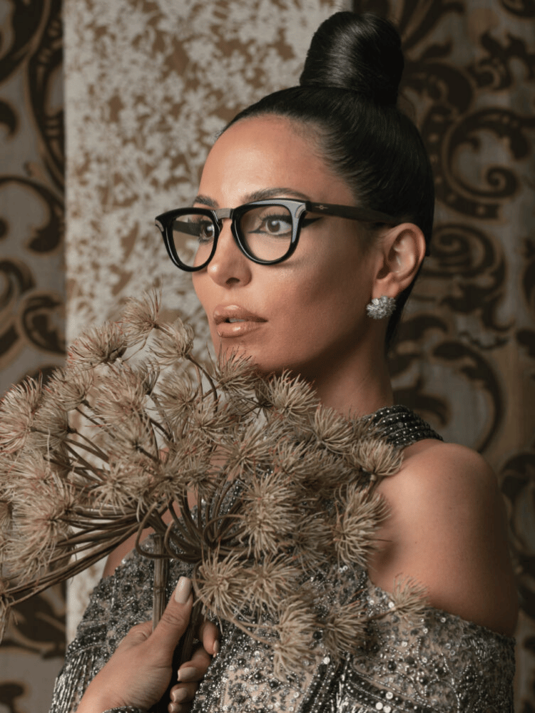 A woman wearing glasses is holding a bunch of flowers.