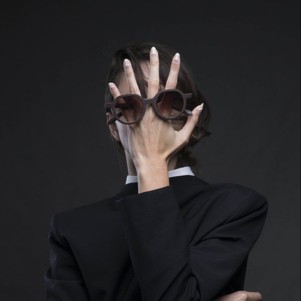 A woman wearing VAKAY sunglasses covering her face with her hands