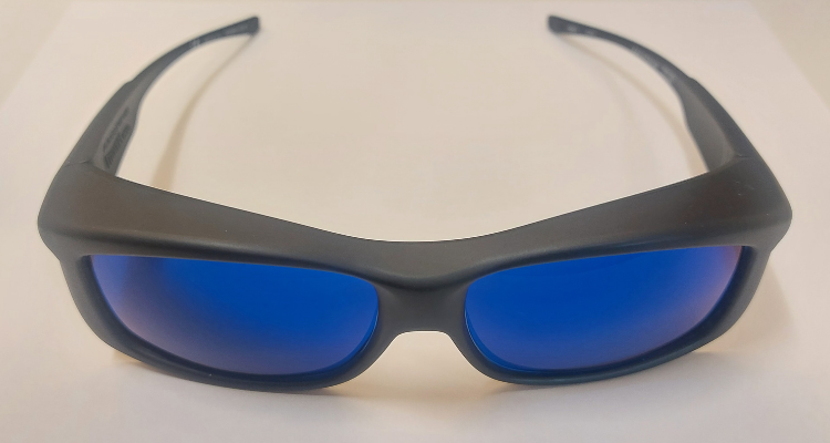 A pair of black sunglasses with blue lenses on a white surfac