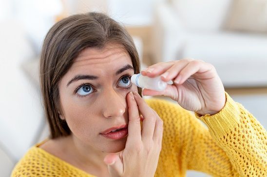 Woman using eye drop woman dropping eye lubricant