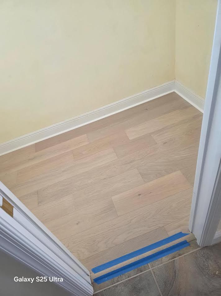 Small empty closet with light wood flooring and beige walls, viewed from the doorway.