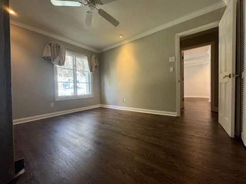 Empty living room with dark wood floors, gray walls, tray ceiling, and a window with curtains