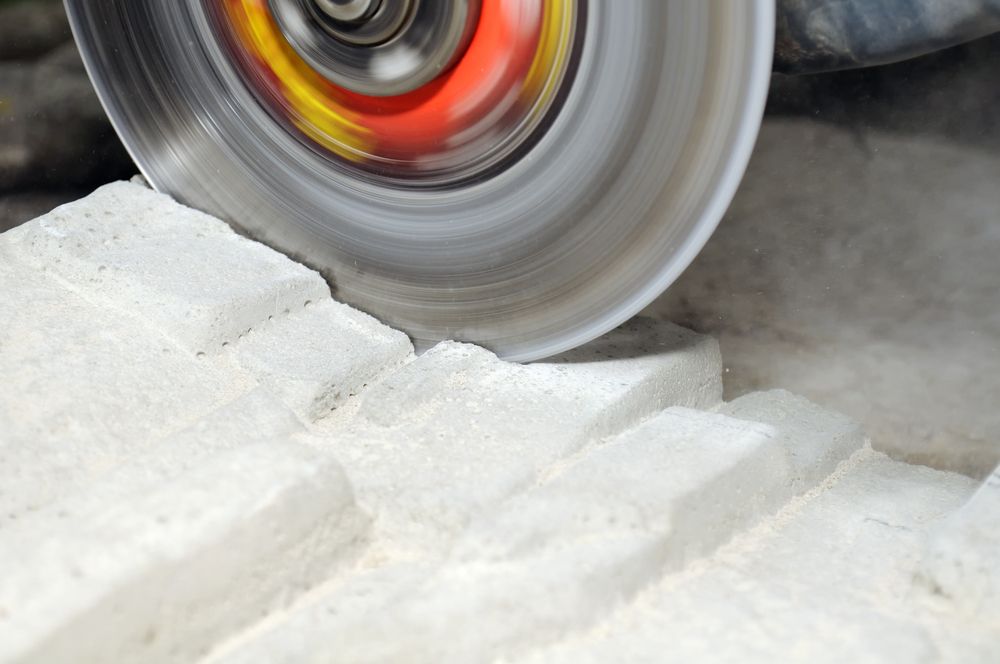 A Man Is Using A Circular Saw To Cut Concrete — Accu-Cut In Manunda, QLD