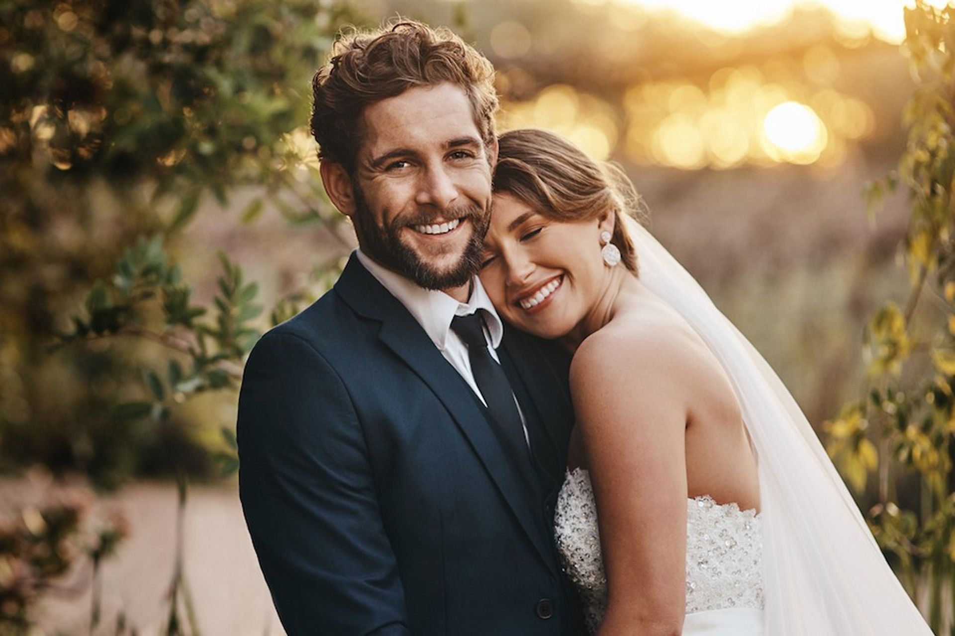 A bride and groom are posing for a picture on their wedding day.
