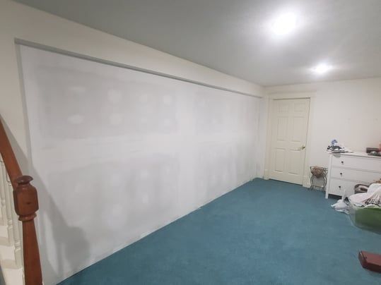 A room with a blue carpet and a white wall.