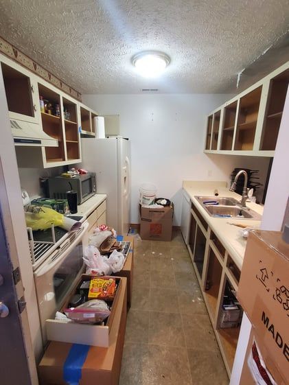 A kitchen with boxes on the floor and a box that says made on it