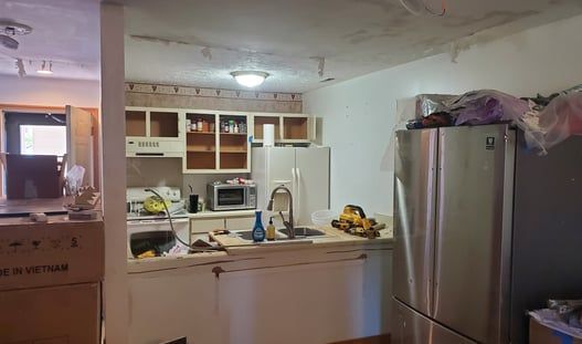 A kitchen with a refrigerator , sink , stove and microwave.