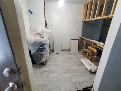 A room that is being remodeled and covered in plastic.