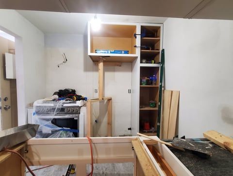 A kitchen under construction with a stove and cabinets