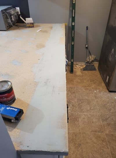 A can of paint is sitting on a counter in a kitchen.