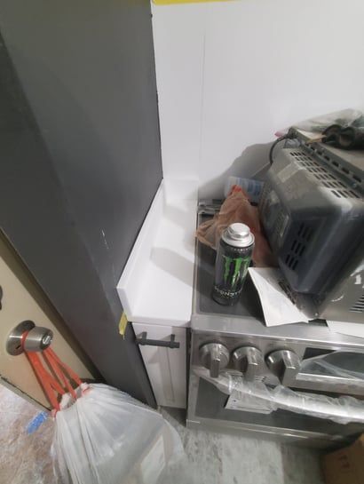 A can of monster energy drink sits on top of a stove