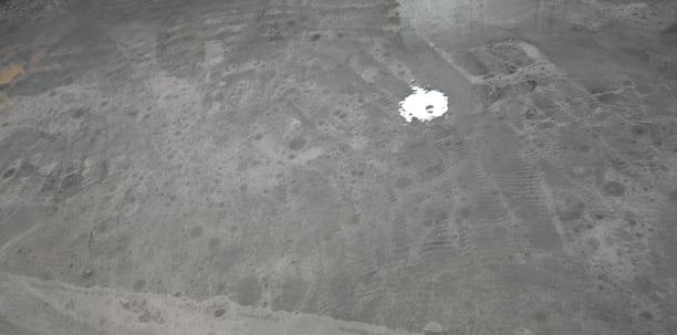 A gray concrete floor with a white circle in the middle.