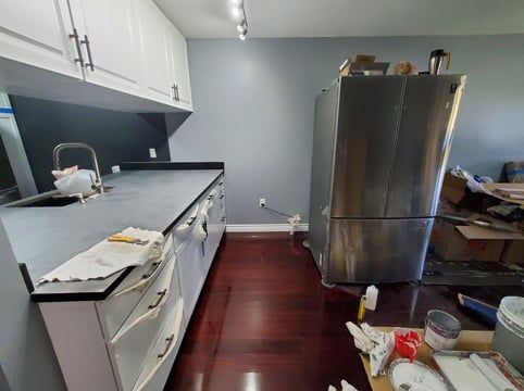 A kitchen with a stainless steel refrigerator and a sink.