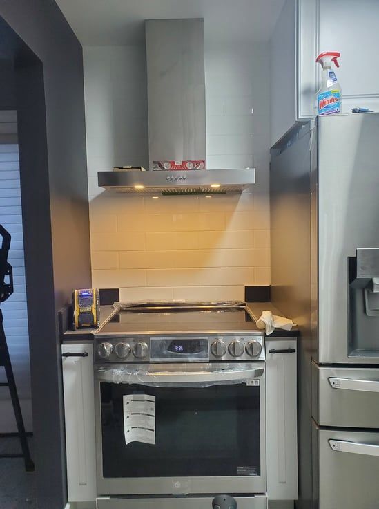 A kitchen with a stove top oven and a refrigerator