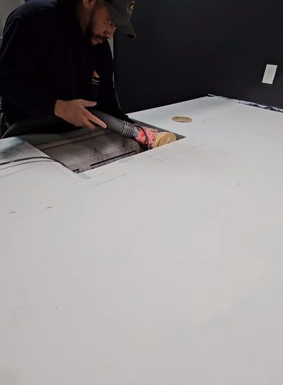A man is cutting a piece of paper on a table.