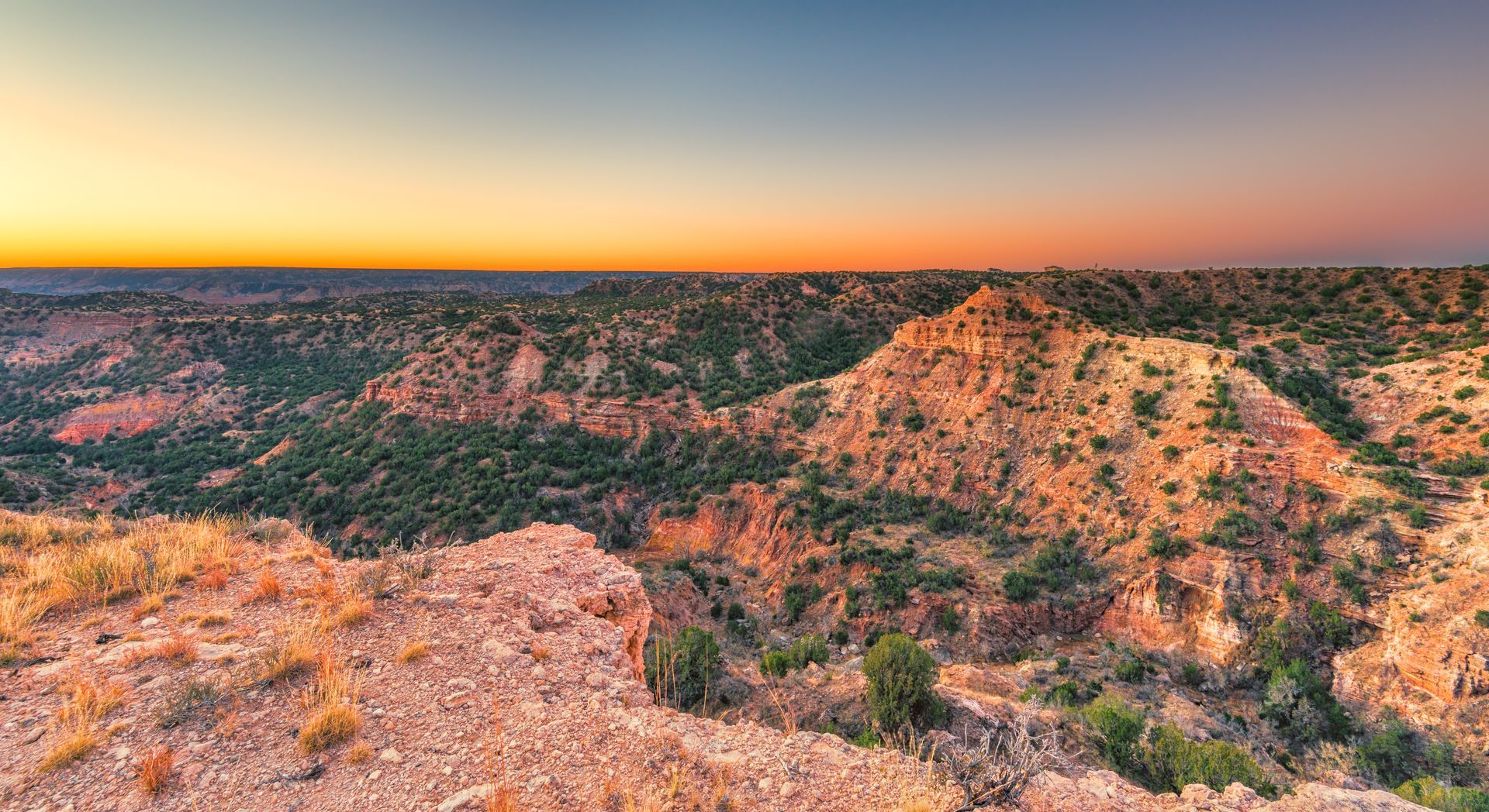 A panoramic view of a desert landscape at sunset.