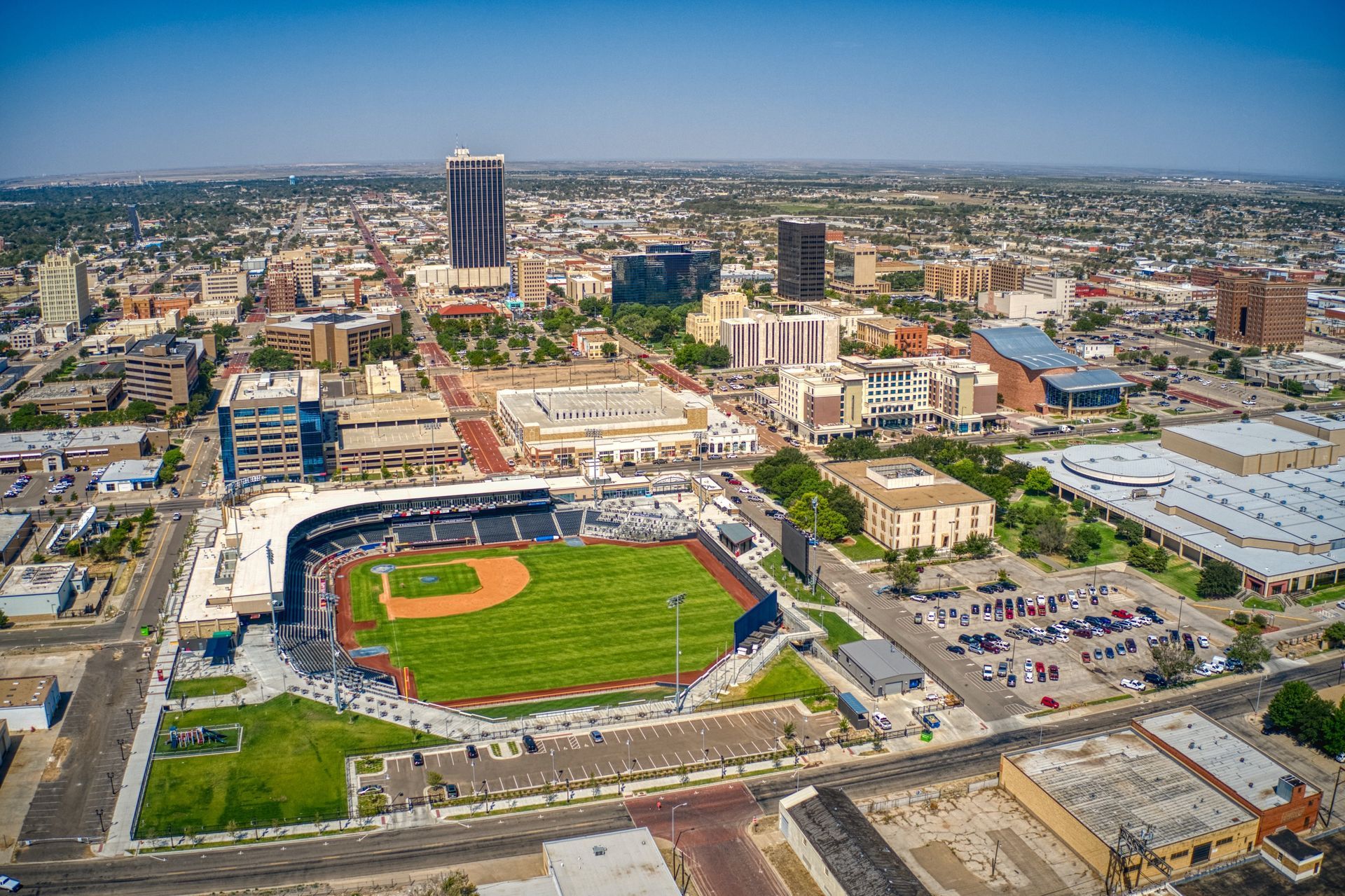 An aerial view of a baseball stadium in a city.