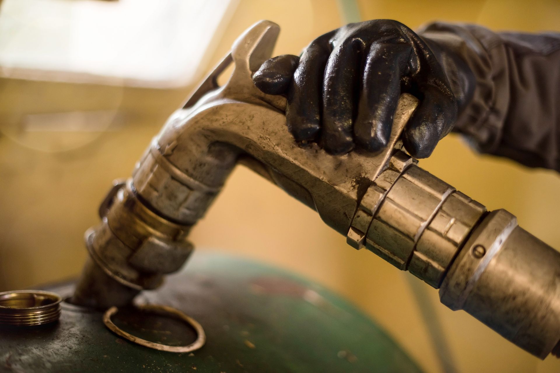 A person is holding a hose that is connected to a tank.
