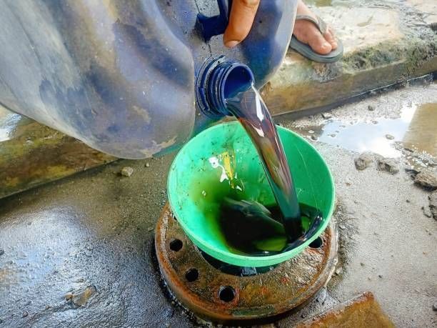 A person is pouring liquid into a green bowl.