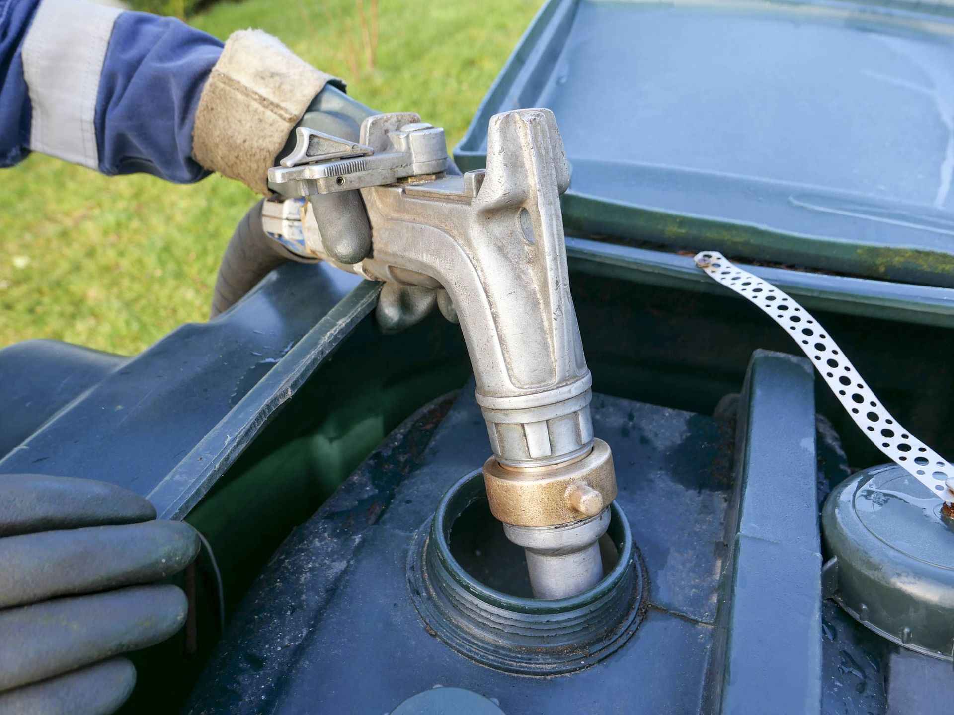 A person is pouring gas into a tank of a car