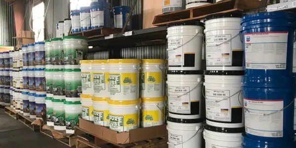 A warehouse filled with lots of buckets of paint.