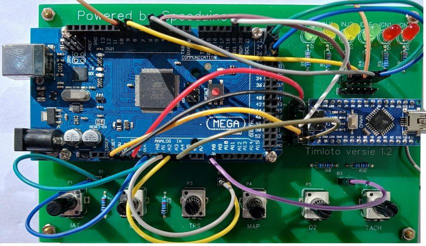 Arduino ontwikkelbord met aangesloten breadboard en diverse bedrading, gemonteerd op een printplaat met draaiknoppen en LED-indicatoren voor elektronica-experimenten.