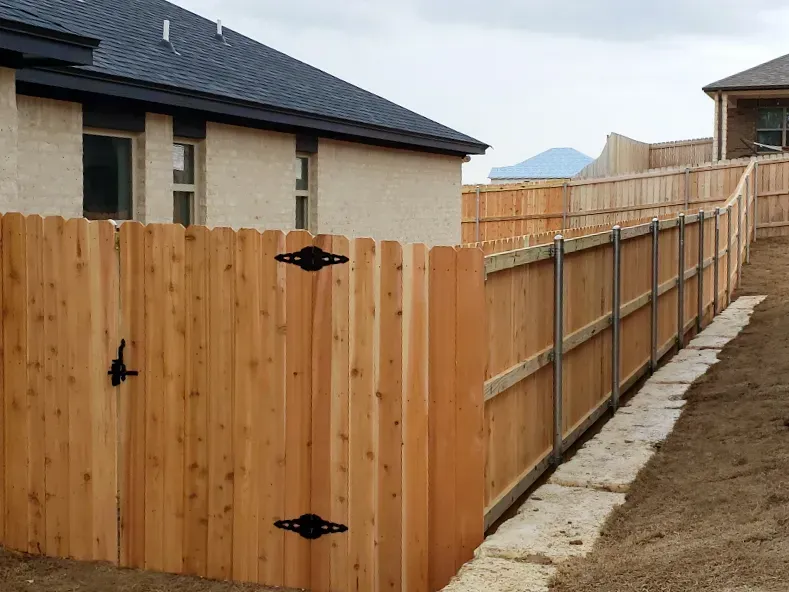 Wooden fence and gate in backyard setting.