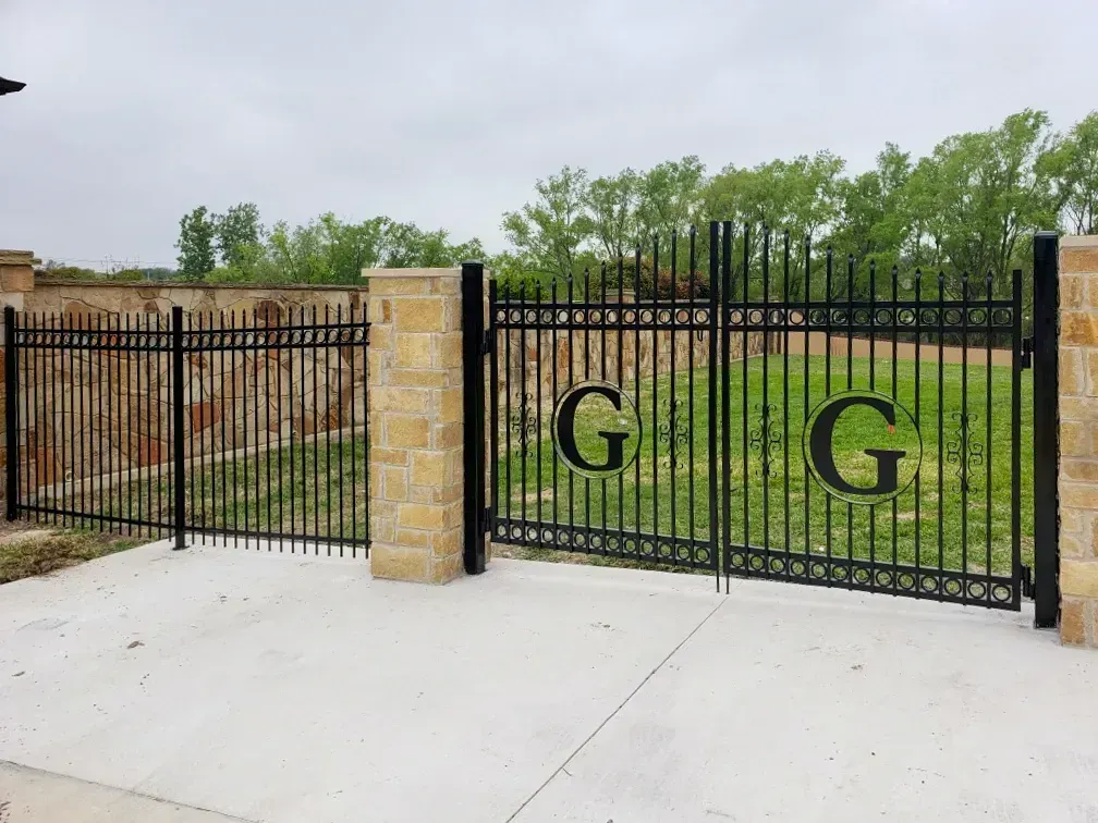 A black gate with the letters g and g on it