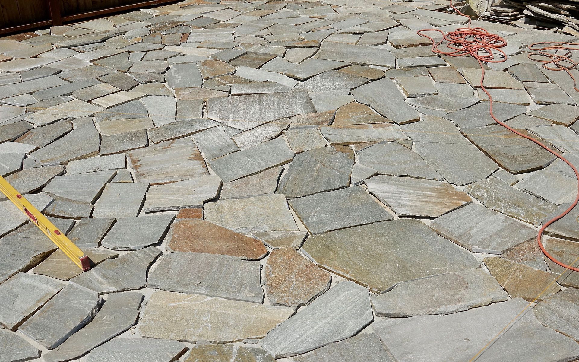 Flagstone patio with irregular stone shapes in shades of gray and beige.