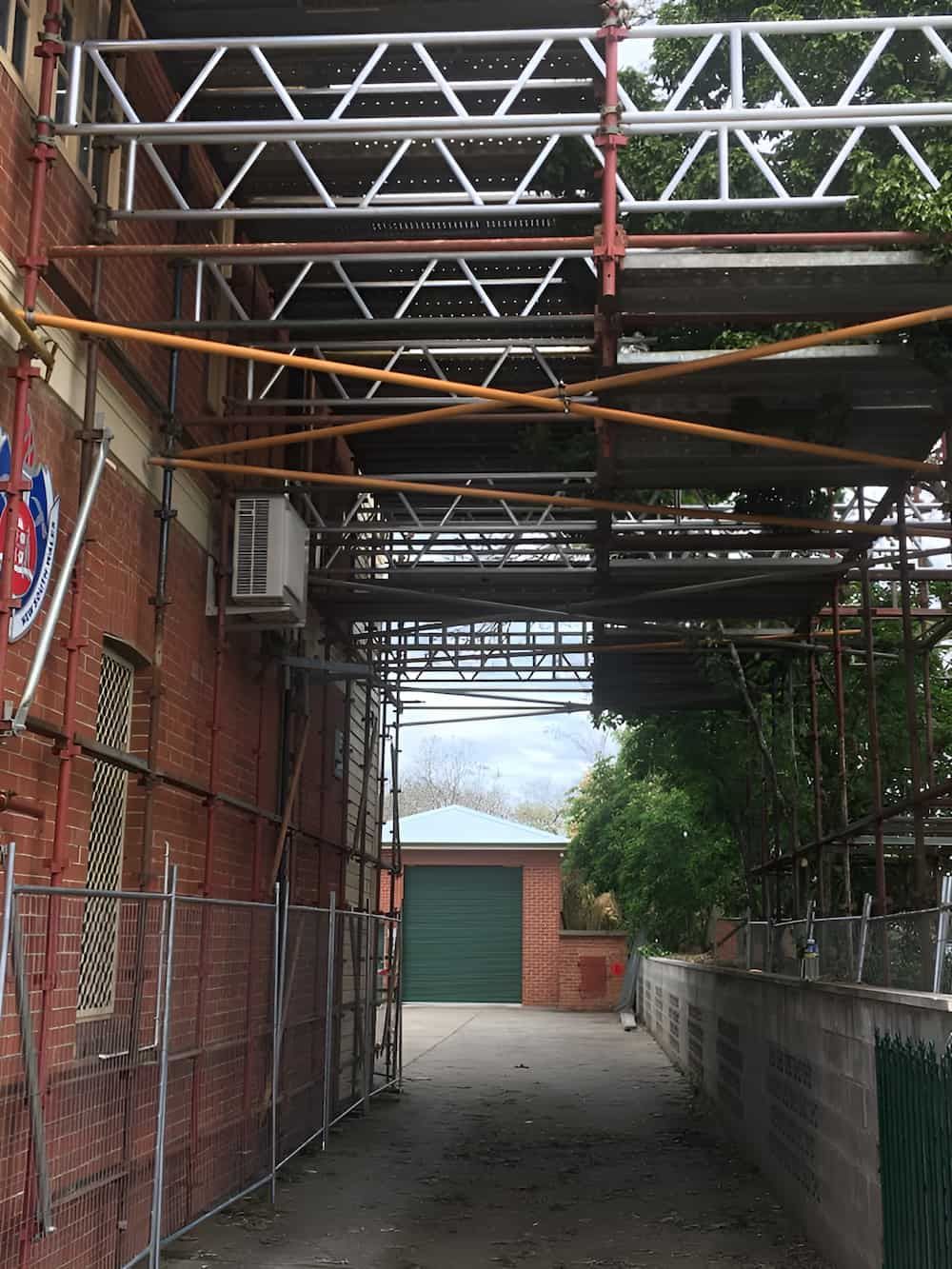 A Brick Building with Scaffolding — Big River Scaffolding Solutions Pty Ltd in Maclean, NSW