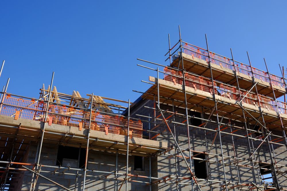 Building Under Construction With Scaffolding Against a Clear Blue Sky