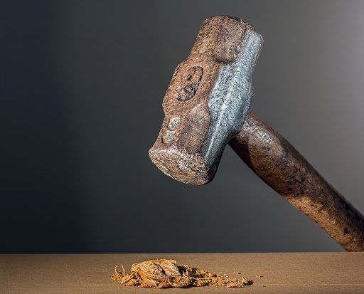 sledge hammer crushes walnut