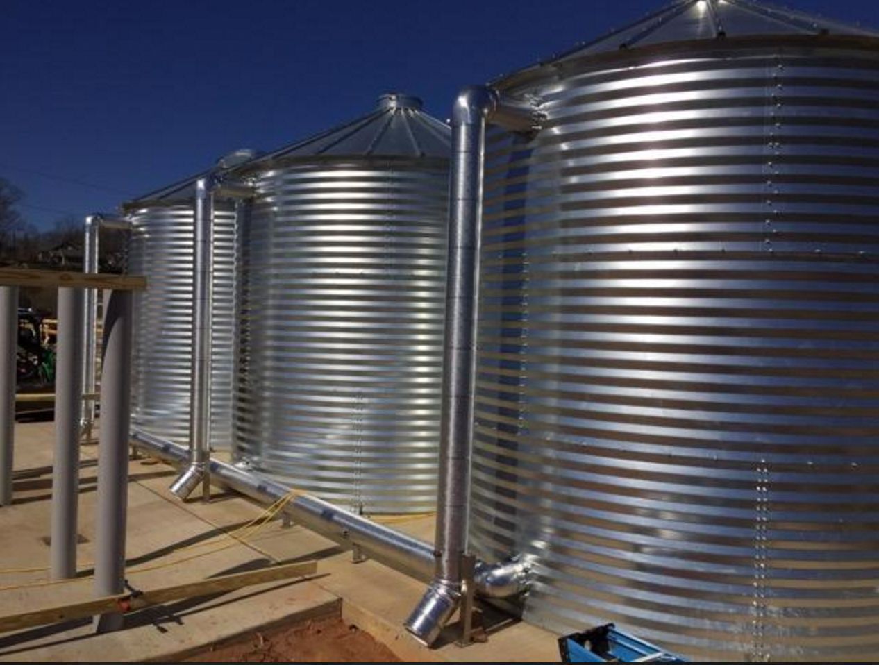 A row of metal silos sitting next to each other on a sunny day.