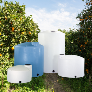A group of water tanks are sitting in a field of oranges