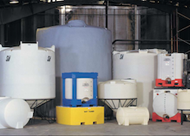 A group of plastic tanks are lined up in a warehouse.