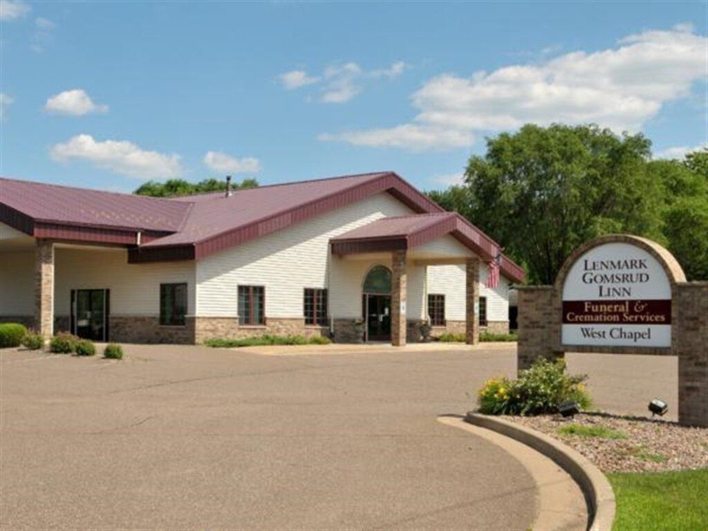 Funeral home with a brown roof and a sign that reads "Lenmark-Gomsrud-Linn."
