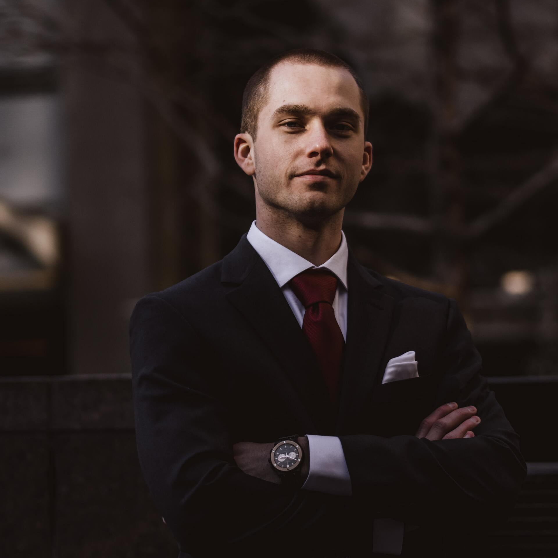 A man in a suit and tie with his arms crossed