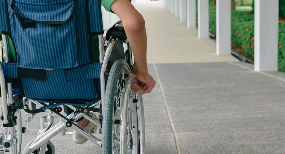 A person in a wheelchair is walking down a hallway.