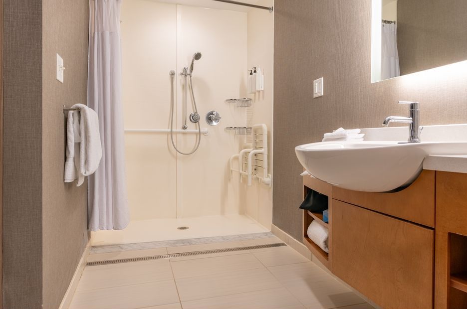 A bathroom with a sink and a walk in shower.