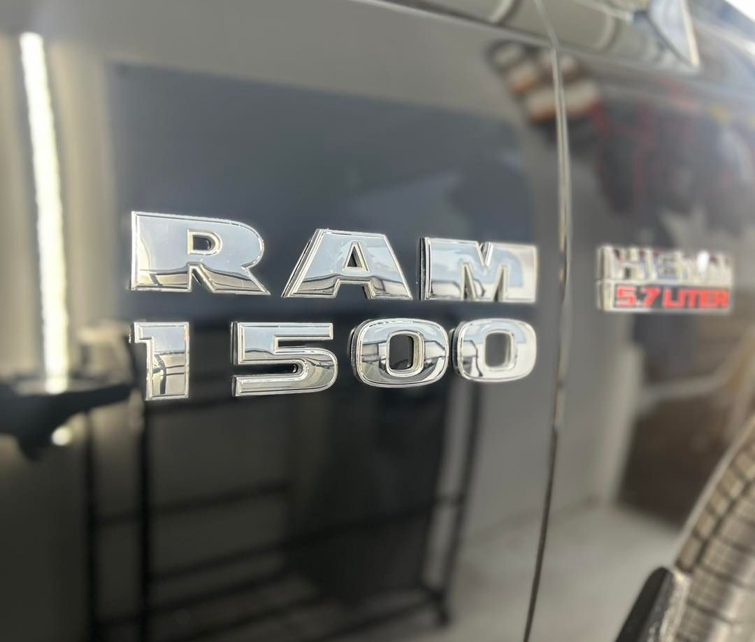 Close-up of a car engine bay, showing a maroon engine cover with red lettering.