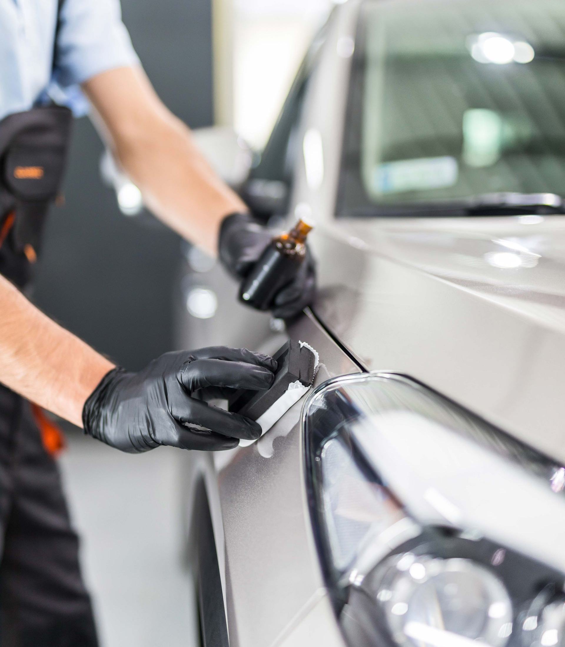 Modesta BC-05 glass coating product with a sample of glass coating held by tweezers on a reflective surface.