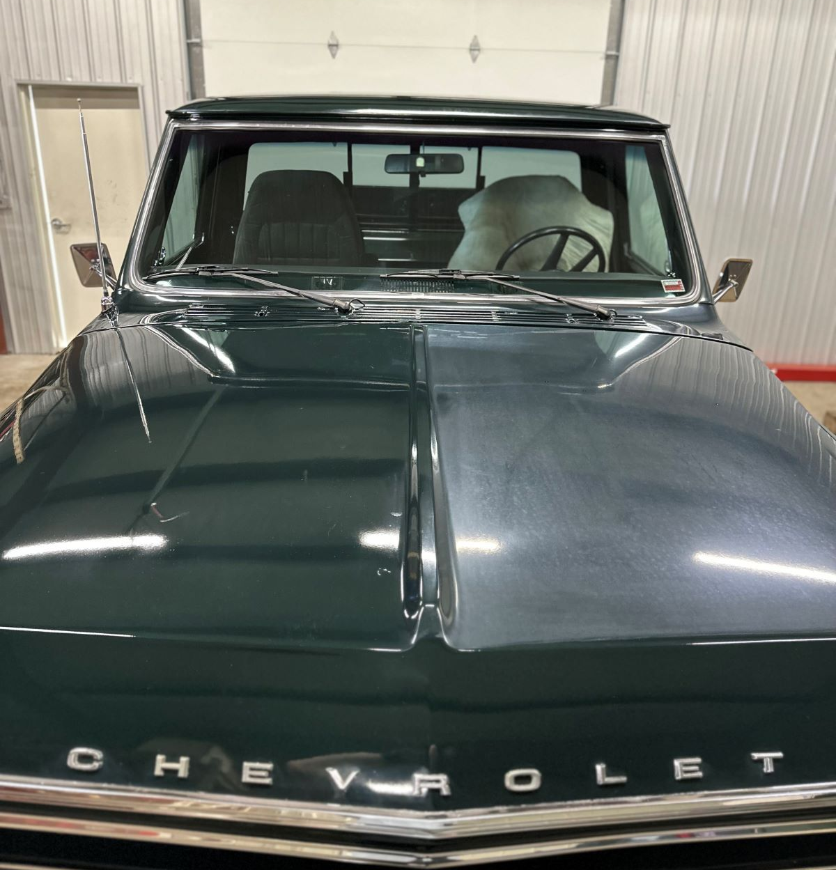 Dark green Chevrolet truck, front view, inside a garage.
