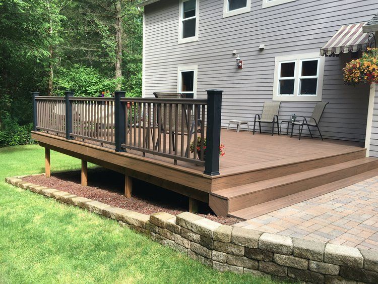 A deck with a canopy and tables and chairs on it.