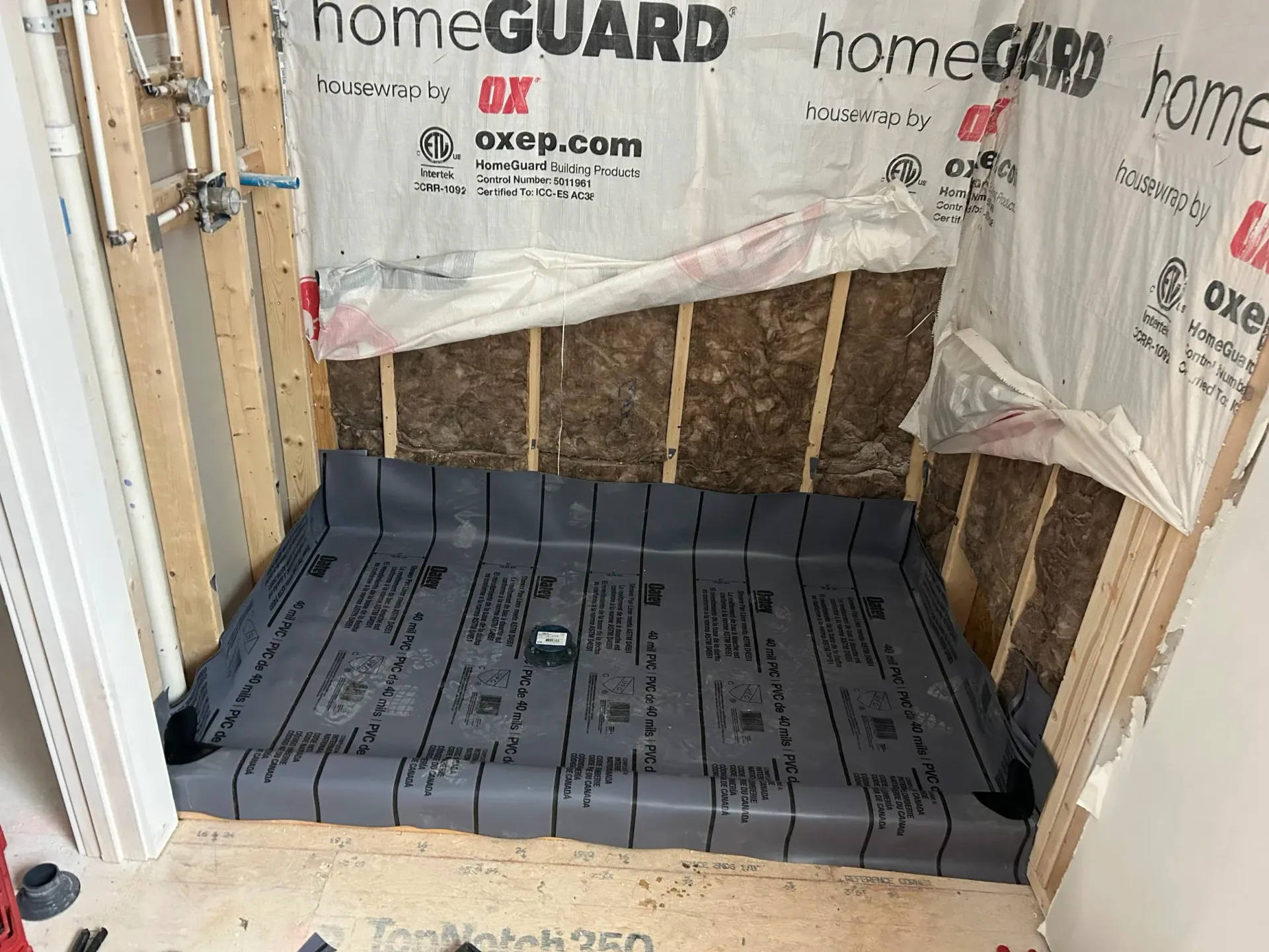 Construction of a shower base. Gray waterproof membrane installed in a framed-out shower stall.
