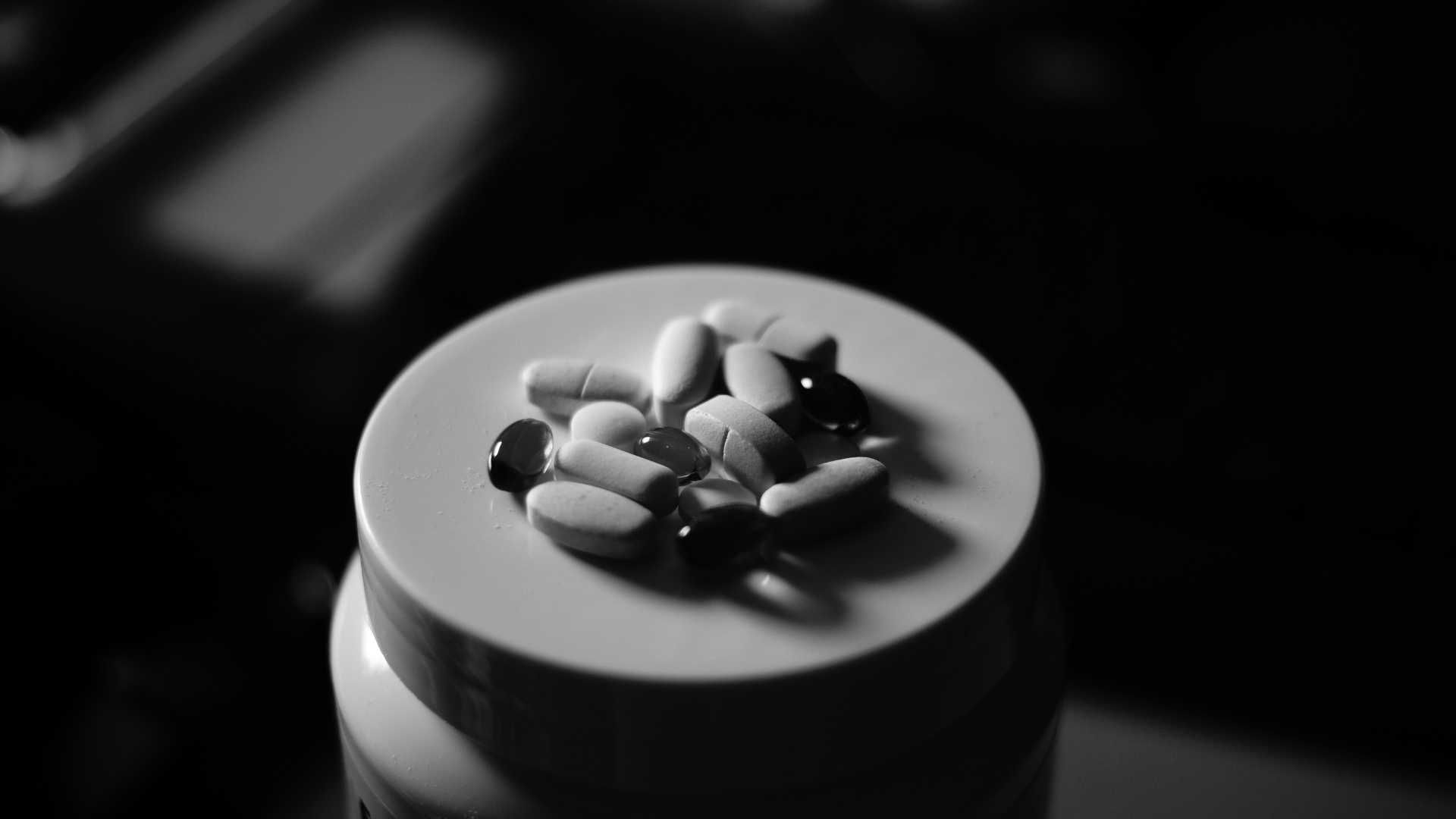 a bottle with pills sitting on the lid