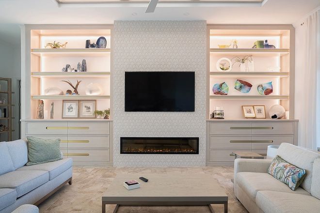 A living room with a fireplace and a flat screen tv on the wall.