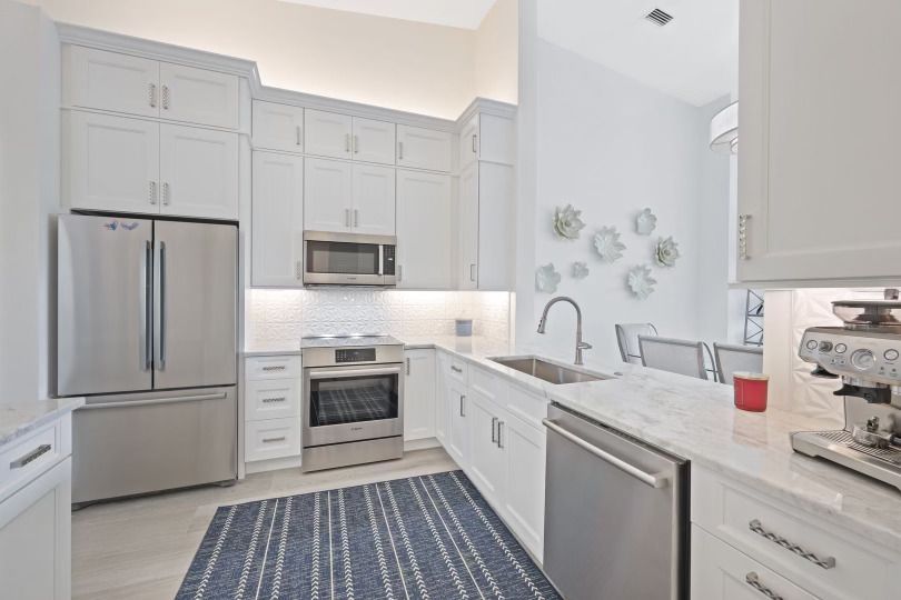 A kitchen with white cabinets and stainless steel appliances.